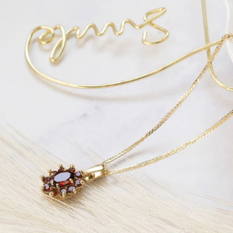 Lucia pendant yellow gold inlaid with garnet stones