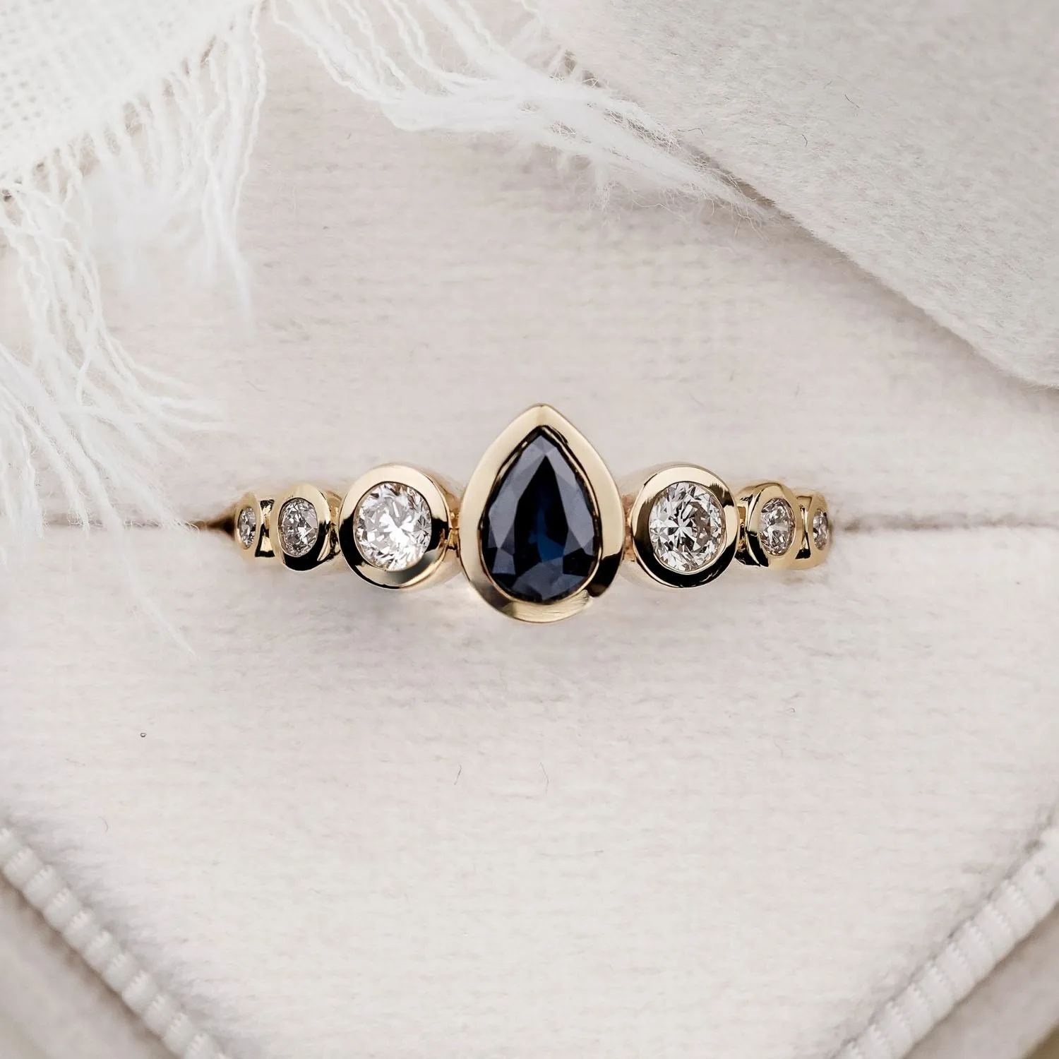 The Lyra - Bezel Set Pear Cut Blue Sapphire Engagement Ring with Diamond Accents