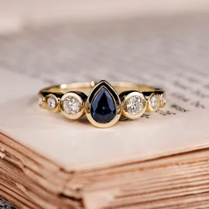 The Lyra - Bezel Set Pear Cut Blue Sapphire Engagement Ring with Diamond Accents